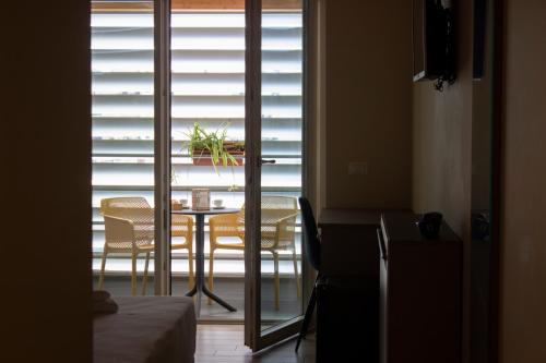 Zimmer mit einem Tisch, Stühlen und einem Fenster in der Unterkunft KRINÒ hotel in Augusta