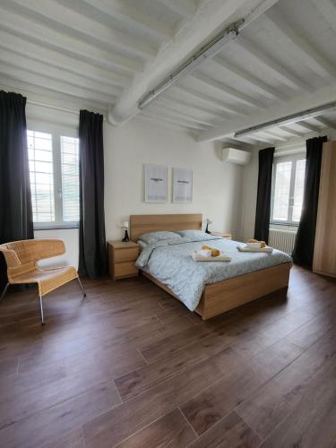 a bedroom with a large bed and a chair at Come a casa vostra in Lucca