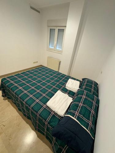 een bed in een kamer met twee handdoeken erop bij Hotelly Atocha in Madrid