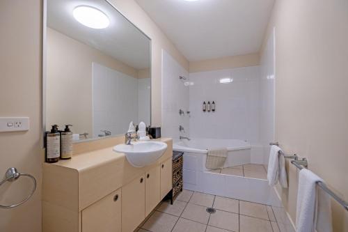 uma casa de banho com um lavatório, uma banheira e um WC. em Absolute Beachfront Penthouse - Ramada Marcoola em Marcoola