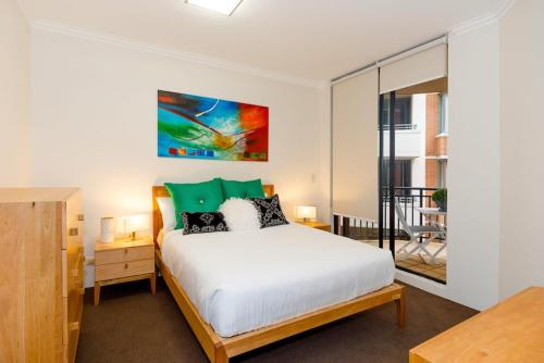 1 dormitorio con 1 cama y balcón en Thriving city location dining hub near CBD, en Sídney