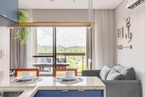 a kitchen and living room with a table and chairs at MARENOSTRUM -VISTA MAR - PRAIA DOS CARNEIROS - ECO RESORT- 2 Suítes in Praia dos Carneiros