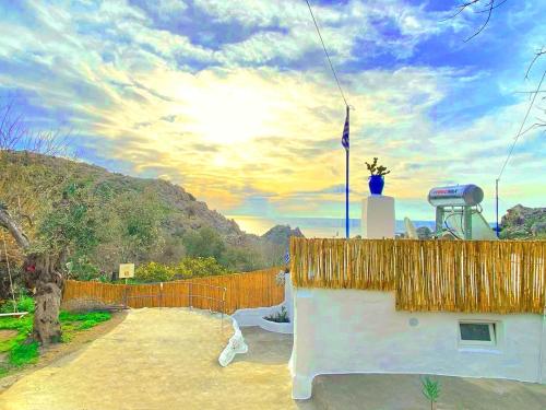 a building with a flag on top of it at Aegean Serenity - Sea View Retreat in Archangelos