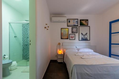 a bedroom with a bed and a bathroom with a shower at Positano Ilhabela Lodges in Ilhabela