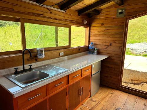 a kitchen with a sink and a window in a cabin at Cabaña Magnolia in Nuevo León