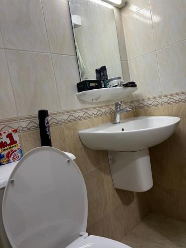 een badkamer met een wit toilet en een wastafel bij Rest house in Seeb