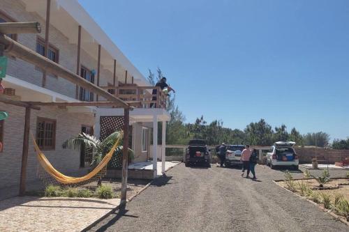 - un homme debout sur le balcon d'un immeuble avec hamac dans l'établissement Bella Praia apartamento Estrela do mar, à Passo de Torres