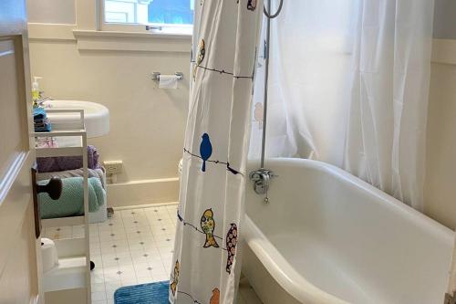 a bathroom with a shower curtain with cartoons on it at Historic Downtown Riverview Flat, No 3 in Astoria, Oregon