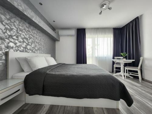 a bedroom with a large bed and a table at PANORAMNA -Guest Rooms in Veliko Tŭrnovo