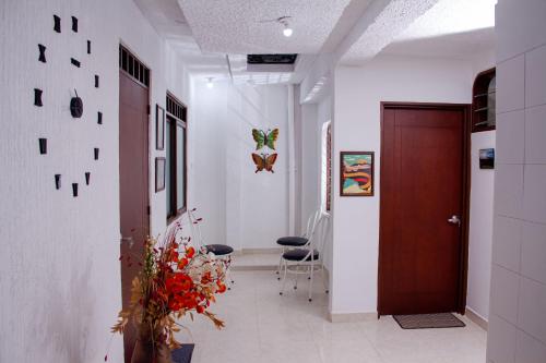 a hallway with a door and flowers in a room at Apartamento confortable, cerca a la Basílica in Buga