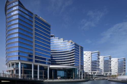 a tall building with blue windows in a city at Marriott Marquis Dubai in Dubai