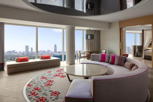 a living room with couches and a table and windows at Marriott Marquis Dubai Creek in Dubai