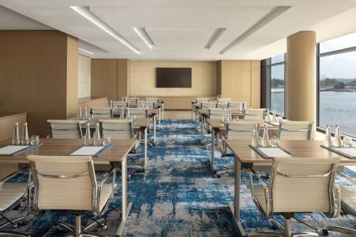 a conference room with tables and chairs and a screen at Marriott Marquis Dubai Creek in Dubai