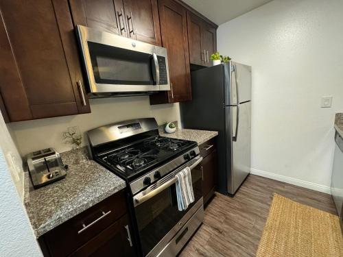 a kitchen with a stove and a stainless steel refrigerator at Incredible Two Bedroom Hollywood Apartments FREE Parking in Los Angeles