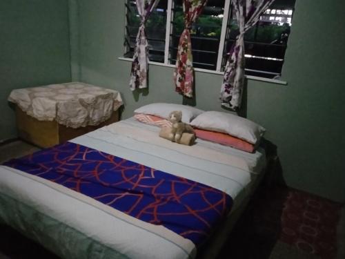 a teddy bear sitting on a bed in a bedroom at AerowView Home Retreat in Matei