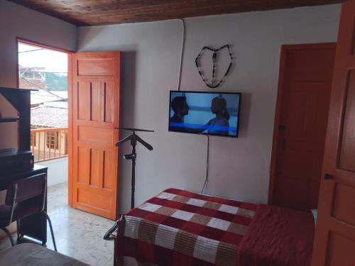 a bedroom with a bed and a tv on the wall at Casa de la Abuela in Jardin