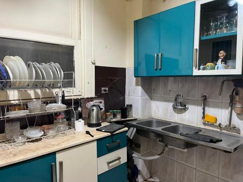 una cocina con armarios azules y fregadero en Beautiful apartment in the heart of cairo en El Cairo