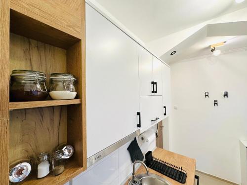 a kitchen with white cabinets and a sink at Golden Oasis in Belgrade