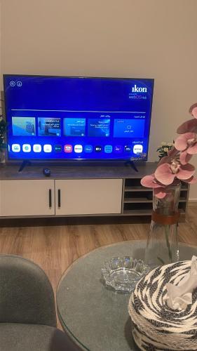 a living room with a tv and a table with a glass table sidx sidx sidx at ستارت 3 in Hail