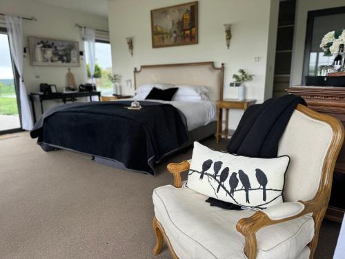 um quarto com uma cama, uma cadeira e um sofá em Luxury winter escape with Mountain Views by Scotch Hill Truffle Farm em Neerim South