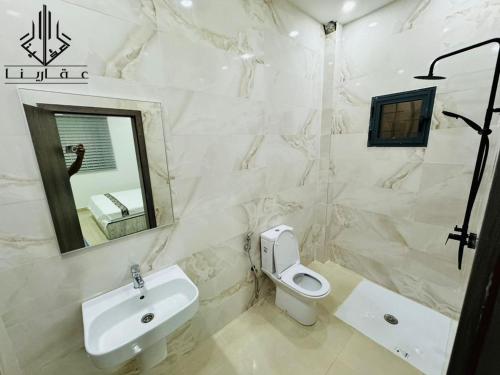 La salle de bains est pourvue d'un lavabo, de toilettes et d'un miroir. dans l'établissement Agharina furnished apartments, à Nouakchott
