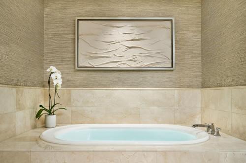 a bath tub in a bathroom with a painting at The Ritz-Carlton, Denver in Denver