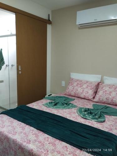 1 dormitorio con 1 cama grande con manta verde en 2 Quartos Novíssimo na Praia de Itaparica com PISCINA e SAUNA, en Vila Velha