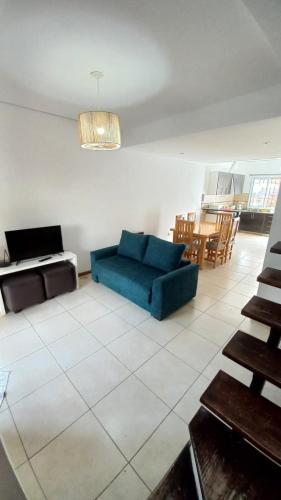 sala de estar con sofá azul y mesa en Alojamiento en Luján de Cuyo en Ciudad Lujan de Cuyo