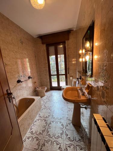 y baño con bañera, lavabo y aseo. en Casa Rossa al Lago - Apto grande primo piano, en Spinone Al Lago
