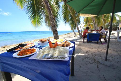 uma mesa azul com comida na praia em Casa Rural El Paraíso de Saona em Mano Juan