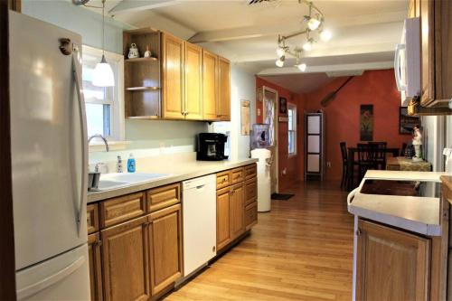 a kitchen with wooden cabinets and a white refrigerator at Riverfront Property in NRG National Park near Sandstone Falls- Wi-Fi, Pet-Friendly in Hinton