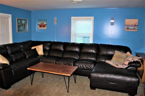 a living room with a black leather couch and a table at Riverfront Property in NRG National Park near Sandstone Falls- Wi-Fi, Pet-Friendly in Hinton