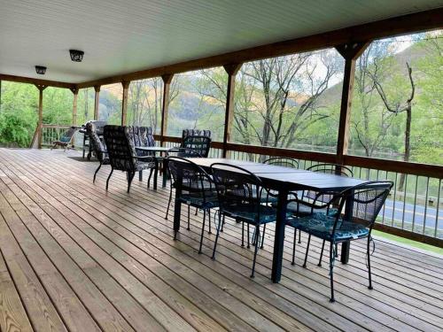 a porch with a table and chairs on a deck at Riverfront Property in NRG National Park near Sandstone Falls- Wi-Fi, Pet-Friendly in Hinton