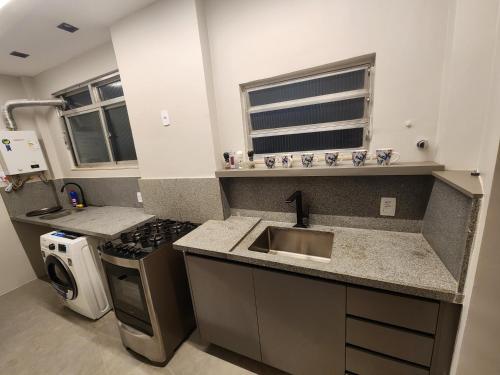 a kitchen with a sink and a stove at Apartamento Modernizado in Rio de Janeiro