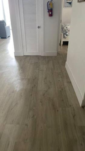 a living room with a wooden floor and white walls at Cozy newly furnished apartment , on the 6th floor. in Sunny Isles Beach