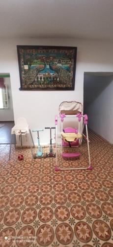 a room with a pink chair on a tile floor at Villa tradesionelle in Ghazoua