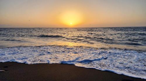a sunset on the beach with the ocean at Casinha Nova - Comfort & Class in Fogo in São Filipe