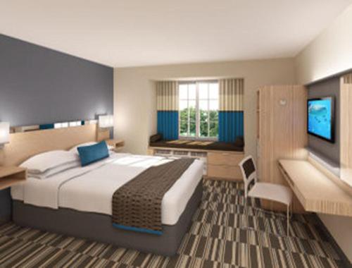 um quarto com uma cama grande e uma televisão em Microtel Inn & Suites by Wyndham Altoona em Altoona