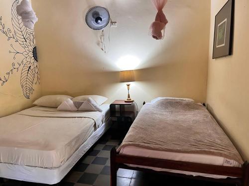 a bedroom with two beds and a lamp on the wall at ViaVia Leon in León