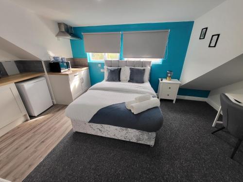 a bedroom with a large bed with a blue wall at Stay Sleep Rest - Forest Road in Nottingham