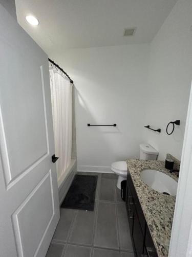 a white bathroom with a sink and a toilet at White Baltimore Condo in Baltimore
