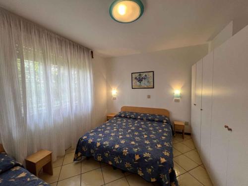 ein kleines Schlafzimmer mit einem Bett und einem Fenster in der Unterkunft Apartments in Lignano 21662 in Lignano Sabbiadoro
