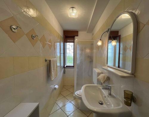 ein Badezimmer mit einem Waschbecken, einem WC und einem Spiegel in der Unterkunft Apartments in Lignano 21662 in Lignano Sabbiadoro