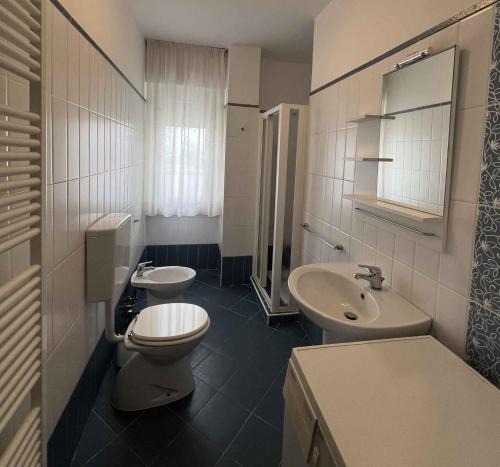een badkamer met 2 wastafels, een toilet en een spiegel bij Apartments in Lignano 21657 in Lignano Sabbiadoro