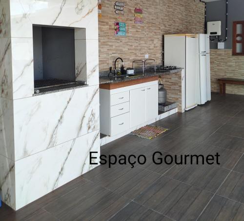 Pardinho的住宿－Recanto Orlumahe，厨房配有白色橱柜和冰箱。