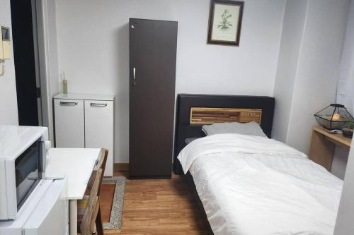 a small bedroom with a bed and a kitchen at Kiman09 in Seoul