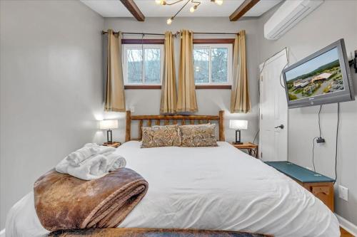 a bedroom with a large bed and a flat screen tv at 180 SKI CAMELBACK-SKI-ON -SKI OFF,SNOW TUBING,Paintball in Tannersville