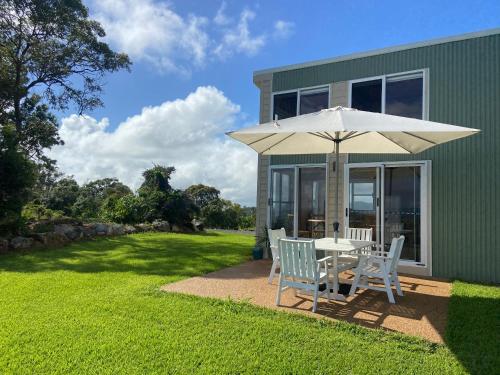 a patio with a table and an umbrella at The Lookout Chalet luxury getaway retreat in Farnborough