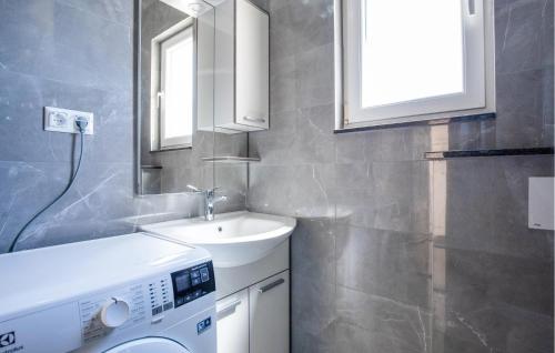 ein Badezimmer mit einem Waschbecken und einer Waschmaschine in der Unterkunft 1 Bedroom Beautiful Apartment In Komarna in Komarna