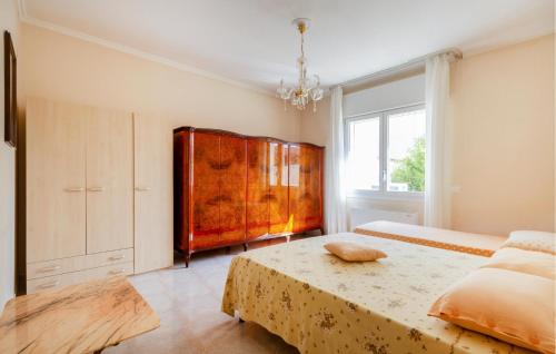 a bedroom with a large bed and a wooden cabinet at Pet Friendly Apartment In Lizzano With Wifi in Lizzano